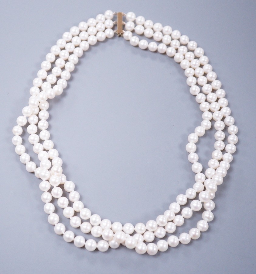 A modern triple strand cultured pearl set choker necklace, with 375 yellow metal clasp, 43cm.